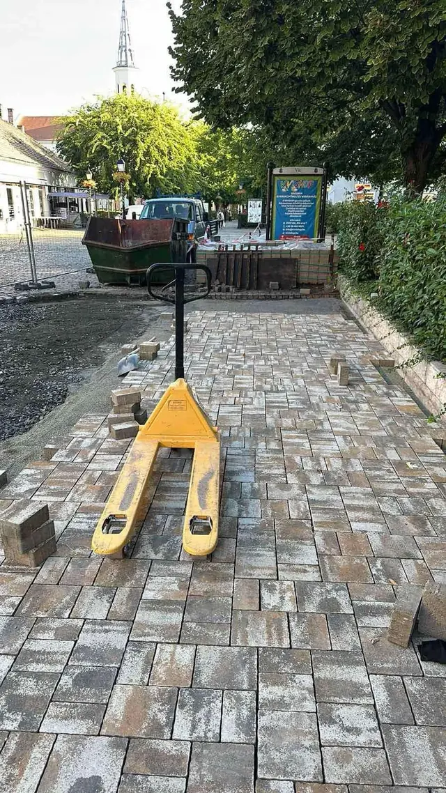 Belvárosi gyalogos utca burkolása melírozott téglakővel, raklapemelővel szállított anyaggal