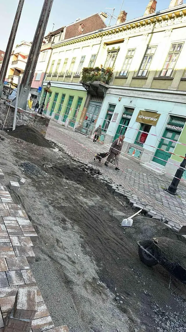 Történelmi belvárosi utca burkolatcseréje: régi kockakő mellett új téglakő ágyazat készül